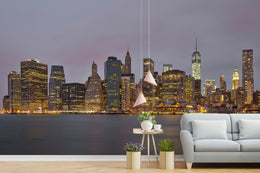 Modern guest room interior showcasing dramatic illuminated skyscraper skyline mural with calm harbor foreground.